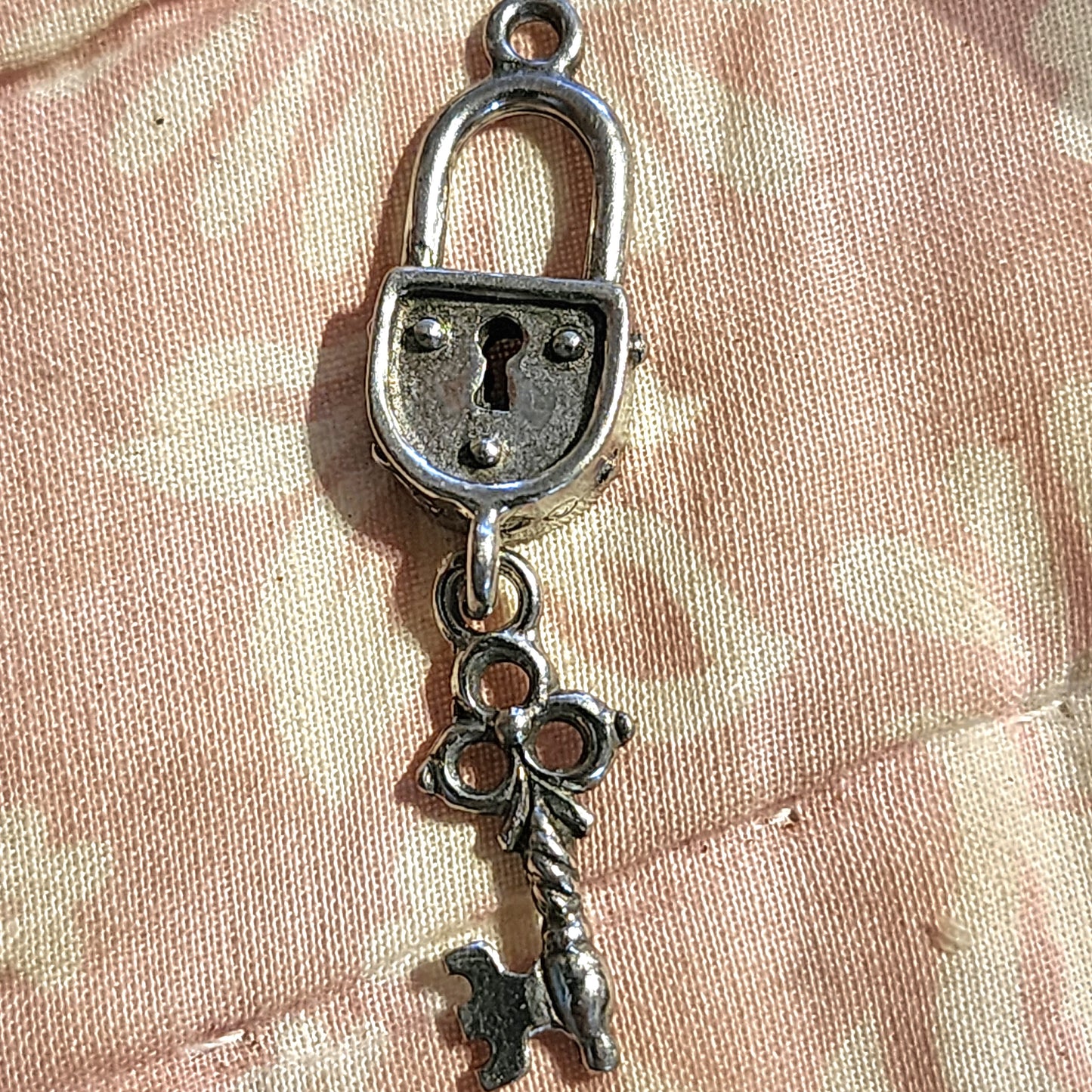 Metal padlock and dangling key charm