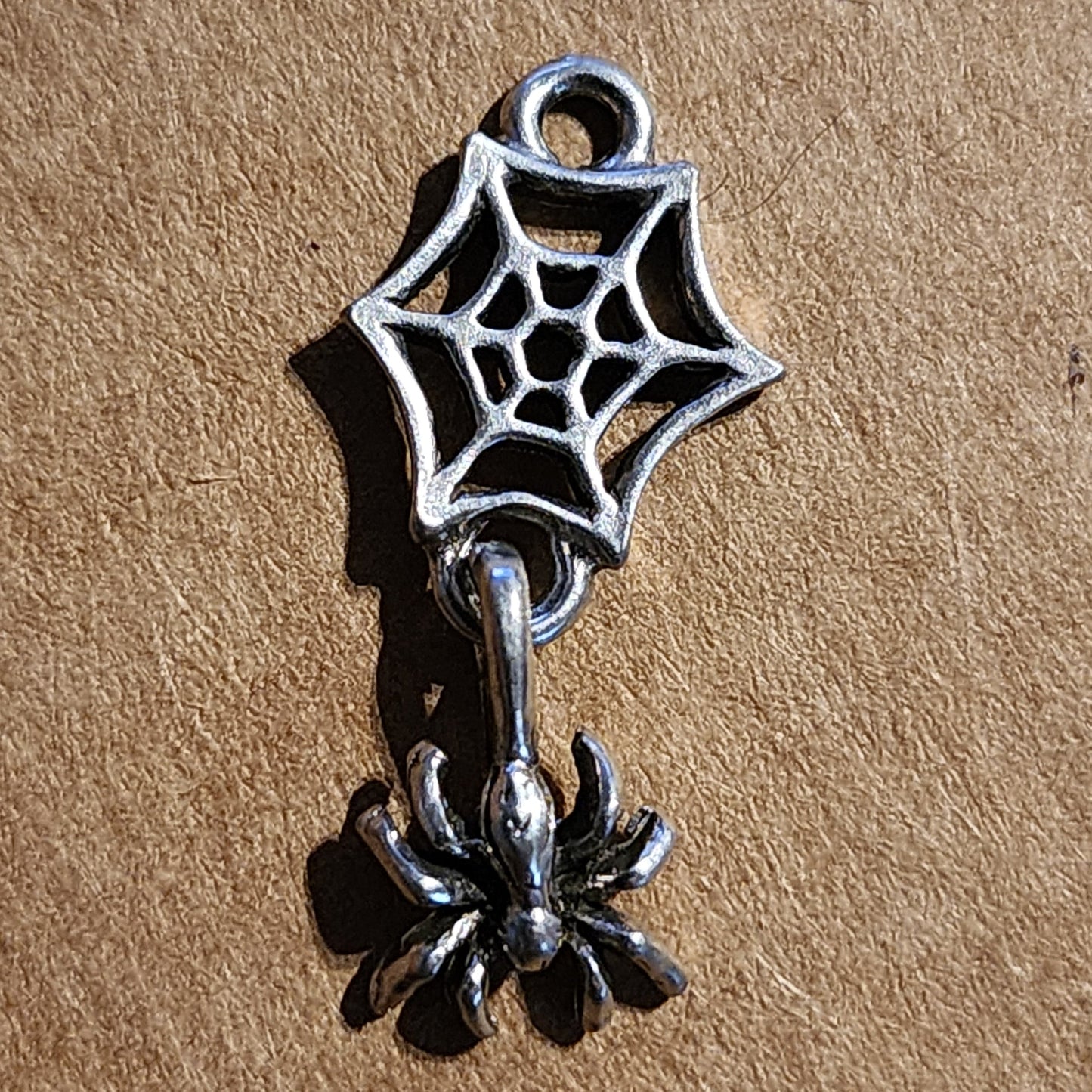 Metal spider web with spider dangle charm